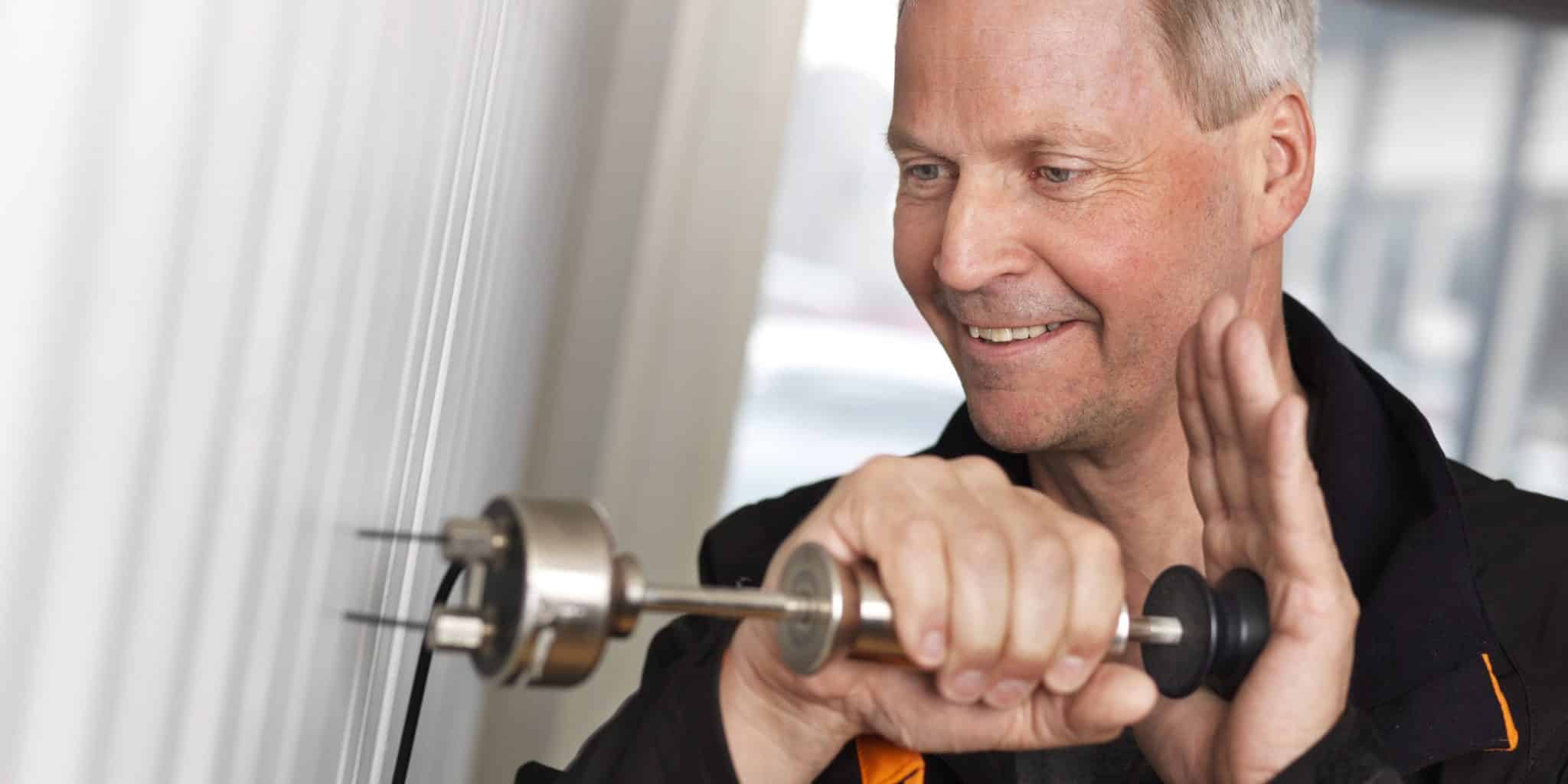 Bilder av mannlig konsulent måler fukt i trevegg