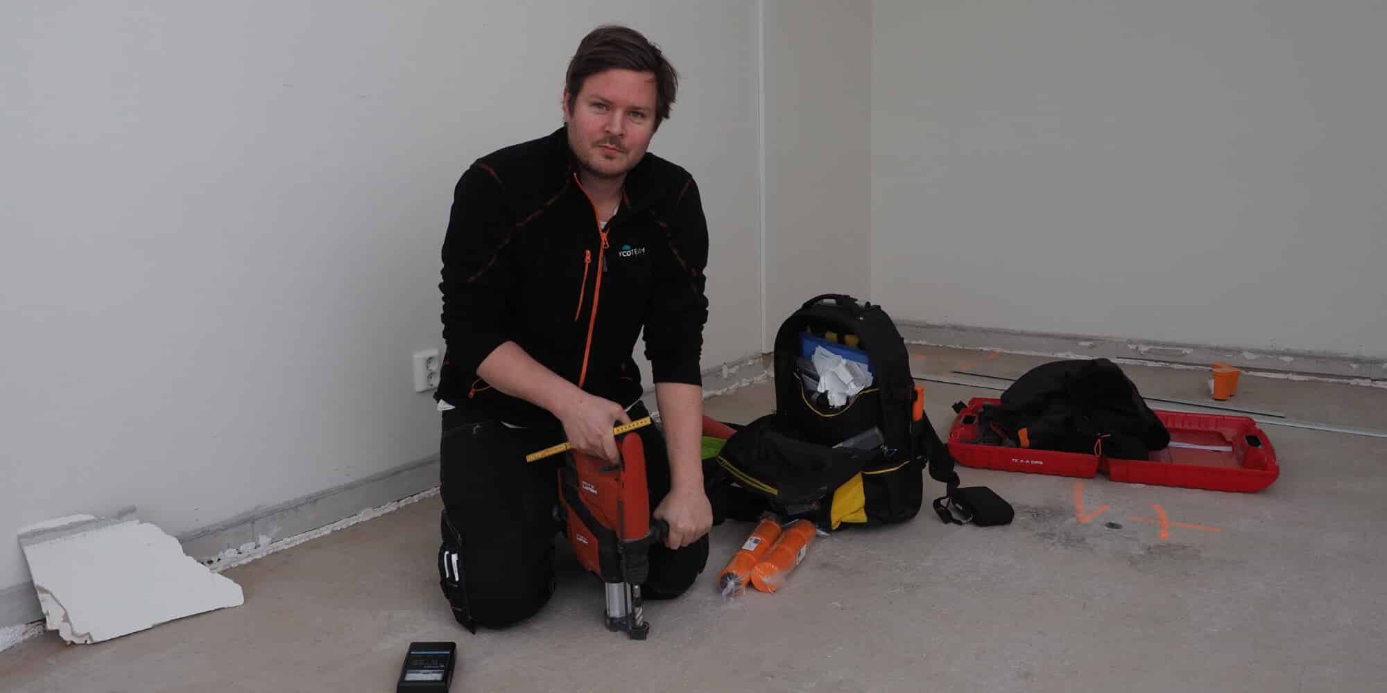 Mann ansatt i Mycoteam måler fukt i betong